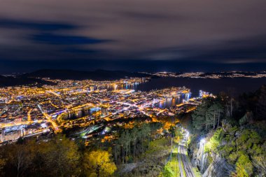 Geceleri arka planda dağ olan bir şehir.