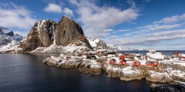 Kayalık bir adada, arkasında dağ olan küçük bir kasaba.