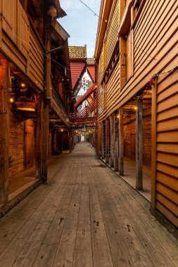 Ahşap binalar ve saat kulesi olan dar bir cadde.