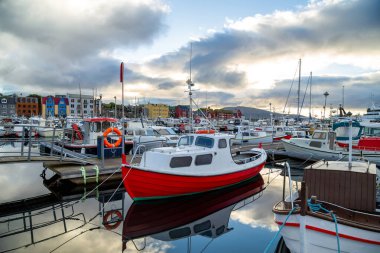 Limanda bir sürü tekne ve bulutlu bir gökyüzü var.
