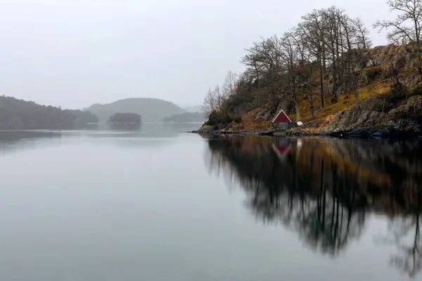 Arka planda dağ olan gölde bir kayıkhane.