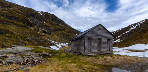 Dağlarda küçük bir kulübe ve arka planda bir dağ.