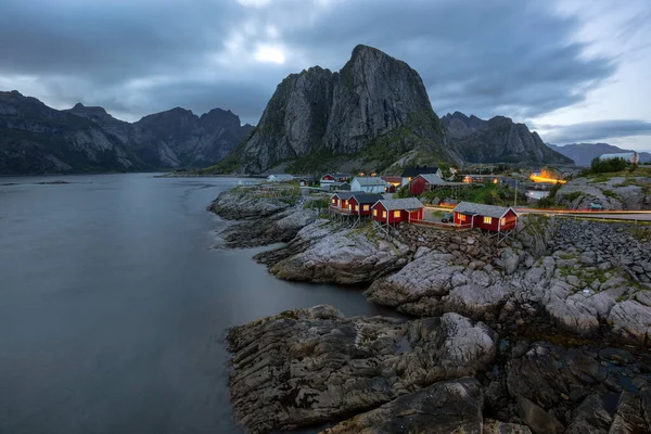 Bir su kütlesinin yanındaki dağın yanından geçen bir tren.