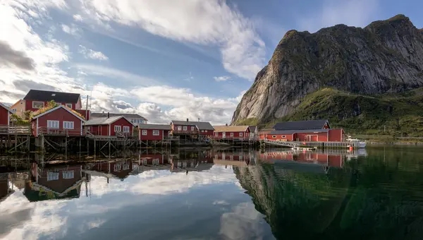 Arkasında dağ olan küçük bir balıkçı köyü.