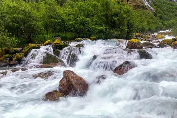 Önünde şelale ve kayalar olan bir nehir.
