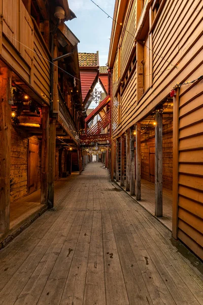 Ahşap binalar ve saat kulesi olan dar bir cadde.