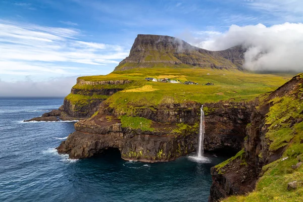 Yeşil bir dağın ortasında bir şelale.