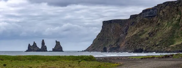 Okyanus kıyısında toprak bir yolda yürüyen bir insan.