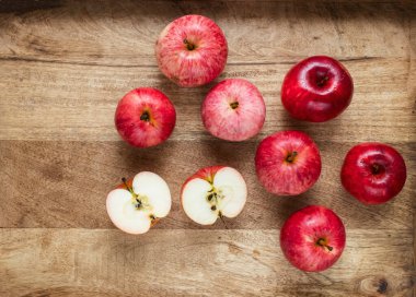 Ahşap arka planda taze kırmızı elmalar. Meyveli kompozisyon, ahşap tepsi.