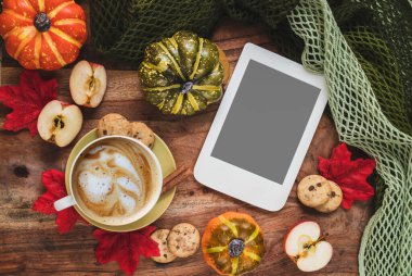 Sonbahar evi kompozisyonu bir fincan kahve, balkabağı, elma, sonbahar yaprakları ve fotokopi alanı olan e-kitap. Feminen blog sosyal medya için sonbahar şablonu.