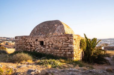 Güneşte eski bir kalenin içinde yuvarlak çatılı eski bir bina. Girit Adası, Yunanistan 'daki Rethymno' daki Venedik kalesi Fortezza.