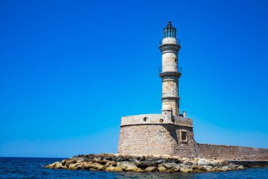 CHANIA, CRETE, GREECE- 21 Haziran 2019: eski Venedik deniz feneri. Suyun yakınındaki kayalık bir tepecikte