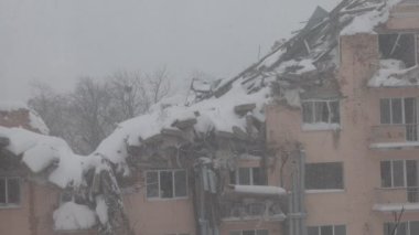 Kırık camlar, yıkık bina, kış günü, ilk kar, ilk kar, terk edilmiş şehir, depresif şehir atmosferi, Ukrayna 'da savaş.