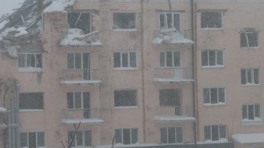 Kırık camlar, yıkık bina, kış günü, ilk kar, ilk kar, terk edilmiş şehir, depresif şehir atmosferi, Ukrayna 'da savaş.