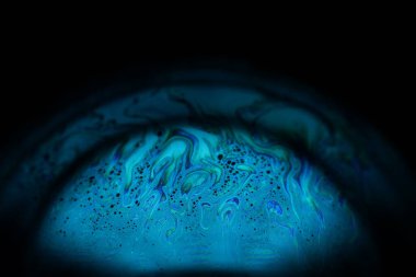 Siyah zemin üzerinde parlak mavi sıvı, yağ lekeleri hareket, parlak kimya, sürreal arkaplan, arktik mavi renk