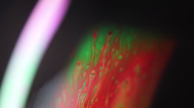 Yeşil fantastik yağlar, koyu arkaplanda parlak bir sıvı, renkli soyut, ışık çizgisi, sürrealist formlar 