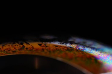 Sıvının makrodaki parlak gökkuşağı yansıması, çok renkli yansımalar, sürrealist arka plan, fantastik düz hareket, su yüzeyi, spektrum dokusu, bilimsel soyutlama 