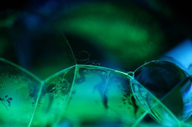 Siyah zemin üzerinde yeşil sıvı yansımaları, sıvı soyutlaması, renk dalgaları, derin koyu arkaplanlar, geometrik su şekilleri, sıvı hareketi, yeşil ve mavi ışık 