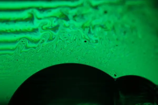 Yeşil sıvı fenomen yapısı, koyu arkaplanda yeşil yağlar, renkli soyut, sürrealist sanat, ışık çizgisi