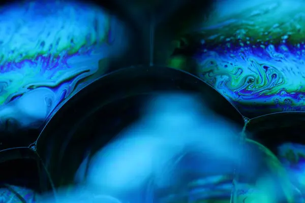 Sıvının makrodaki parlak gökkuşağı yansıması, dağılım, sürrealist arka plan, fantastik düz hareket