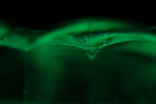 Siyah zemin üzerinde yeşil sıvı yansımaları, sıvı soyutlaması, renk dalgaları, derin koyu arkaplanlar, geometrik su şekilleri, sıvı hareketleri, aydınlatma şekilleri