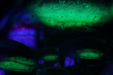 Mor ve yeşil sıvı deseni, su dalgaları, düz hareket, derin renkler, sıvı yüzey yansıması 