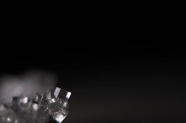 Siyah arkaplanda beyaz kristal, minimalist fotoğraf, yazıtlar için yer, karanlık kopya alanı, tuz kristalleri