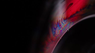 Gri mat sıvısı, koyu minimalist arka plan, erimiş alüminyum yüzey, renkli yansıma. 