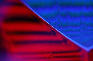 Siyah zemin üzerinde kırmızı ve mor sıvı yansımaları, sıvı yüzey soyutlaması, renk kenarı, derin koyu arkaplan, geometrik su şekilleri, sıvı hareketleri, olağanüstü fiziksel özellikler