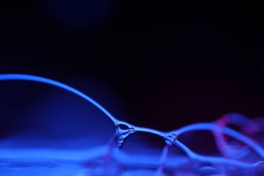 Siyah zemin üzerinde mor sıvı desen, akışkan hareket, karanlık korku arka planı, makro sıvı, düz eğim