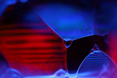 Siyah zemin üzerinde kırmızı ve mor sıvı yansımaları, sıvı yüzey soyutlaması, renk kenarı, derin koyu arkaplan, geometrik su şekilleri, sıvı hareketleri, olağanüstü fiziksel özellikler