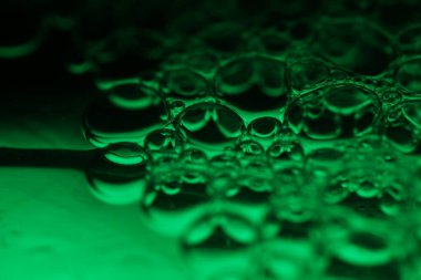 Yeşil kabarcıklar, inanılmaz sıvı bağlantılar, sıvı hareketi, karanlık fantastik arka plan, şeffaf yağ kabarcıkları, kimyasal reaksiyonlar