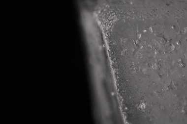 Eriyen buz mikroskopla görülüyor, makroda buz ve suyun hareketi, doğal zemin, siyah zemin üzerinde nesne