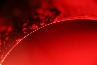 Makrodaki sıvının kırmızı yansımaları, sıvı yüzey, makrodaki kabarcıklar, makrodaki baloncukların bağlantısı, sıvıdan hücre, korku arka planı, mükemmel parlak doku.