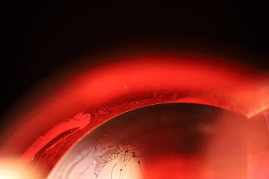 Makrodaki sıvının kırmızı yansımaları, sıvı yüzey, makrodaki kabarcıklar, makrodaki baloncukların bağlantısı, sıvıdan hücre, korku arka planı, mükemmel parlak doku.