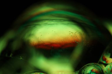 Koyu arkaplanda yeşil sıvı yüzey, makroda sıvının parlak yansımaları, makroda kabarcıklar, makroda baloncukların bağlantısı, sıvıdan hücre, koyu arkaplan