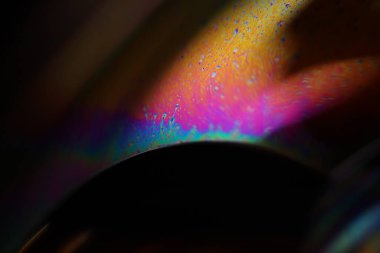 Siyah arkaplanda çok renkli sıvı yüzey, parazit deseni, makro soyutlama 