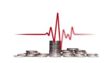 Piles of coins and electrocardiogram. Concept of economic instability.