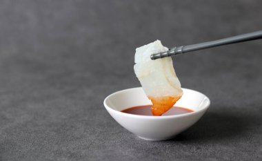 Taze sashimi 'nin yakın plan görüntüsü. Kırmızı biber ezmesine batırılmış taze çiğ balık ve sirke..