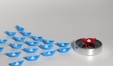 Kırmızı pusula üzerinde mavi kağıt tekneler. Ticari başarı için kavramsal görüntüler.