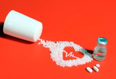 An electrocardiogram-shaped salt and medicine on a red background. Eating salt can increase high blood pressure and heart disease. clipart