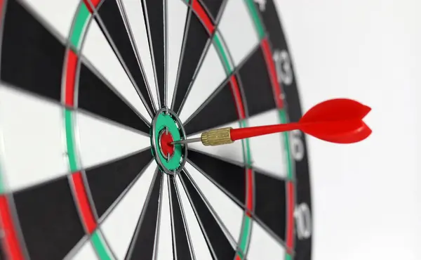 Business marketing success concept. The red dart arrow bullseye in the middle of the dart paper is the goal of the business.