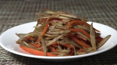 Burdock ve havuç yemeği soya sosunda ya da diğer baharatlarda kaynatılmış. Kore ev yapımı sebze yemekleri..