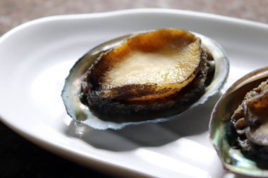 Kore 'nin sağlıklı deniz kulağı. Beyaz tabakta taze deniz kulağı..