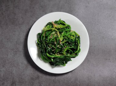 Tuz ve susam yağıyla tatlandırılmış ıspanak sebzeleri. Kore usulü sebze yemeği..