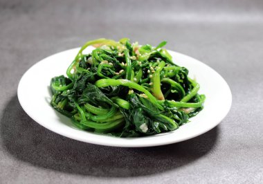 Ispanak yeşillikleri kaynar suda beyazlatılmış. Tuz ve susam yağıyla tatlandırılmış ıspanak sebzeleri..