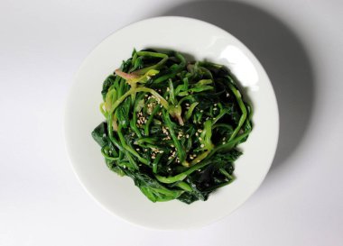 Kore usulü sebze yemeği. Tuz ve susam yağıyla tatlandırılmış ıspanak sebzeleri.. 