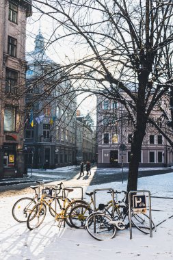 Riga, Letonya - 20 Kasım 2022: Riga, Letonya 'da kış aylarında eski motosikletler zincirle bağlandı ve dolaplar karla kaplandı.