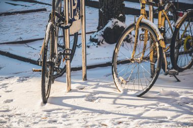 Riga, Letonya - 20 Kasım 2022: Zincirle bağlanmış eski bisikletler ve kışın karla kaplı dolaplar