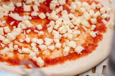 Domates soslu pizza ve ahşap bir tahtanın üzerinde taze mozzarella hazırlıyorum.